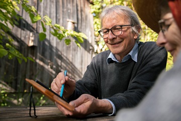 Family manager Heinrich shows his wife something on a tablet