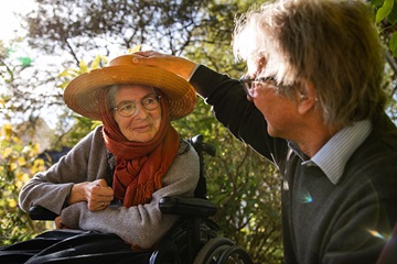 Family manager Heinrich lovingly cares for his wife while enjoying the sun