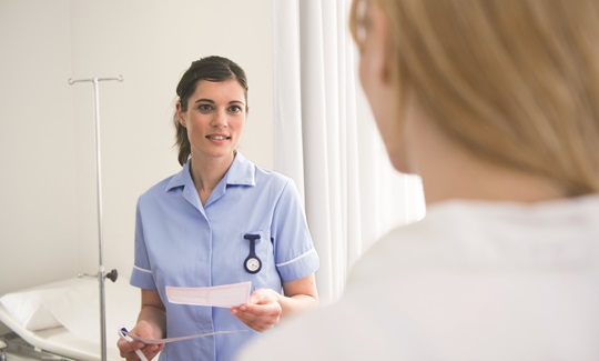 A female nurse talking to a patient.