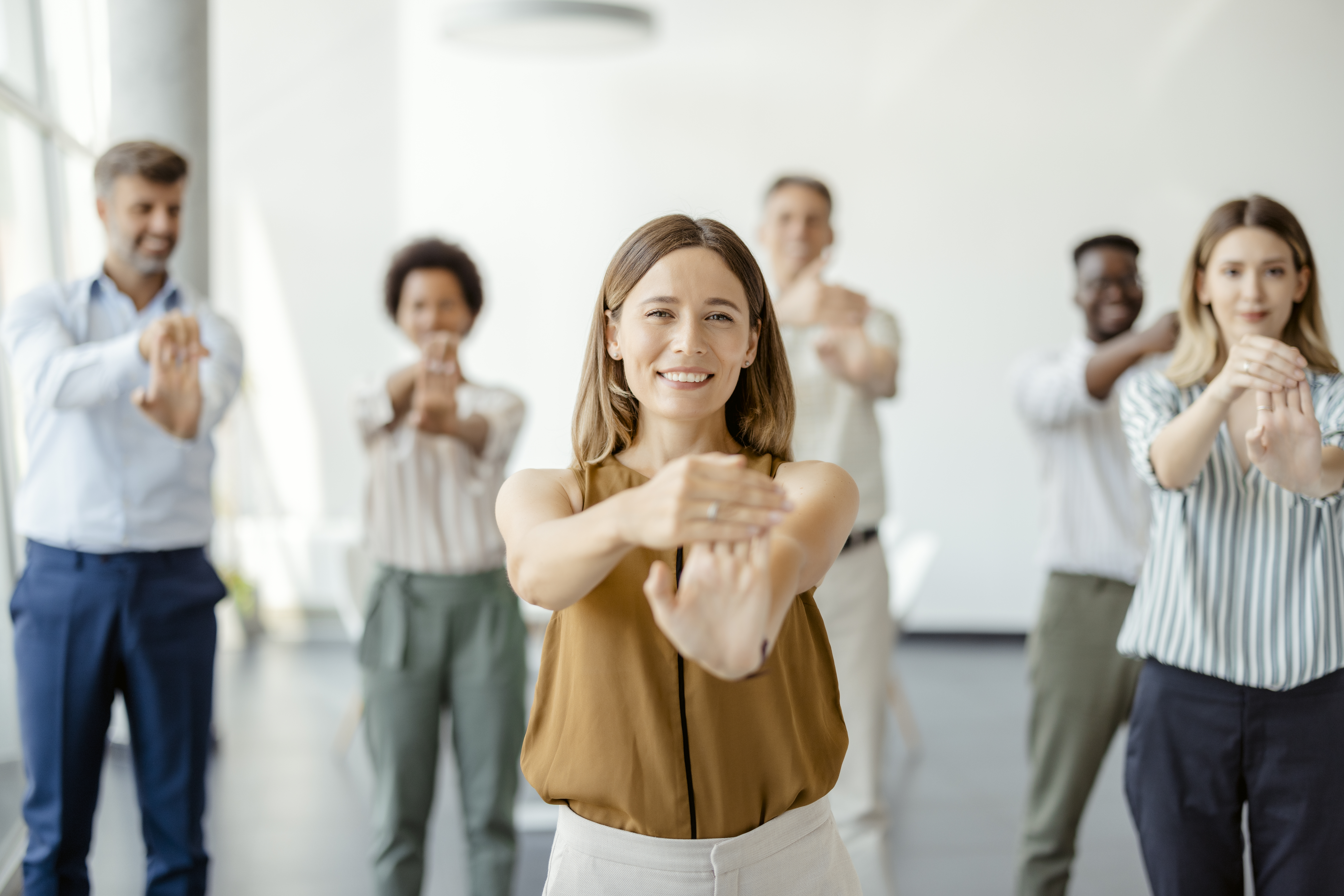 Multiethnic young office employees do workout exercises during break at work