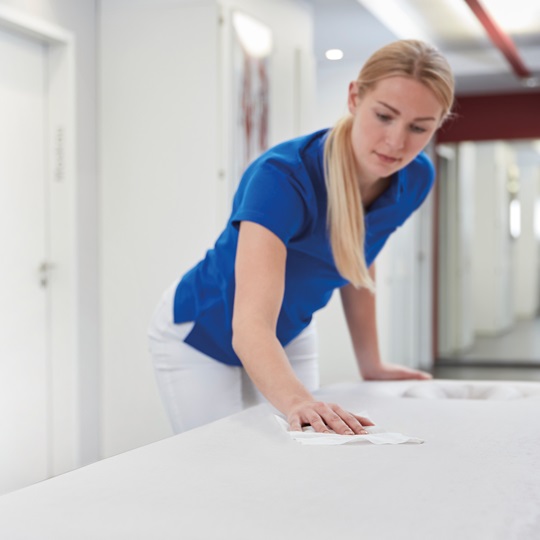 Young women disinfect table in hospital setting with Bacillol Zero Tissues