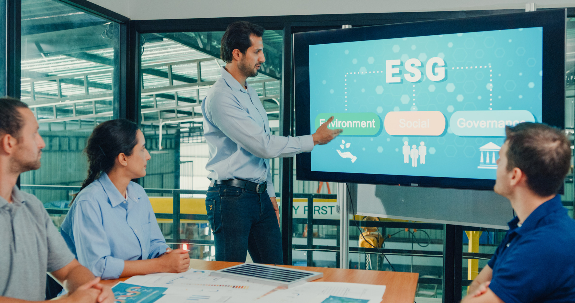  Team of industrial engineers meeting of sustainability renewable energy working focused ESG environmental considerations in manufacturing factory. Sustainable manufacturing plant concept.